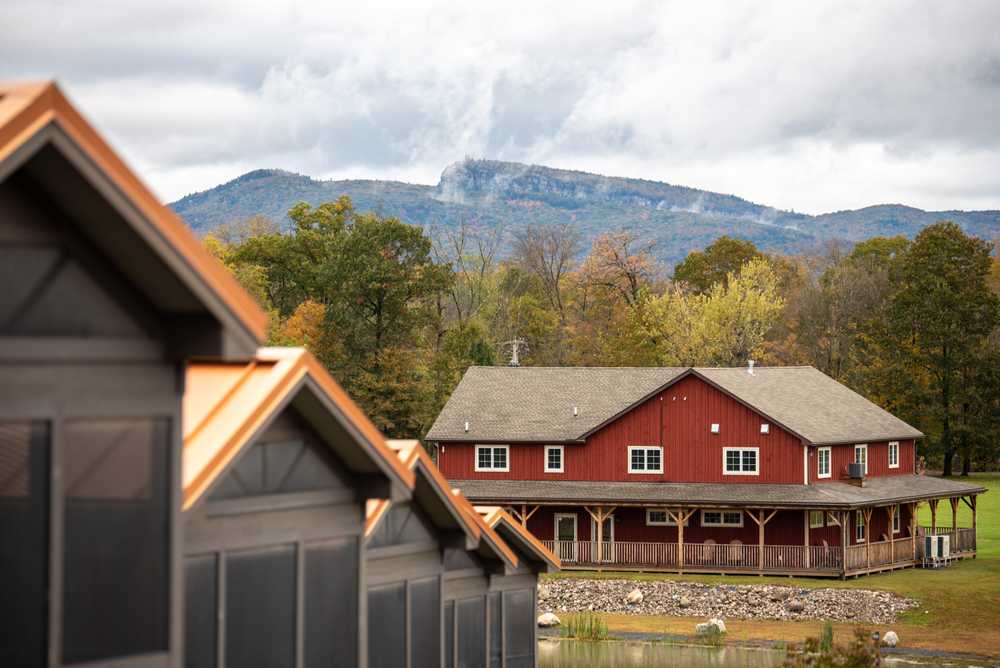 A row of cabins with mountain views in the backdrop.