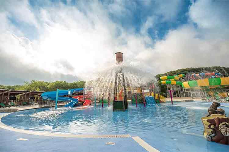Water sprays from an overhead bucket at a campground water park in Texas