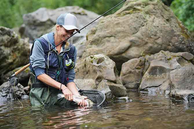 Fly fisherman releasing a fish