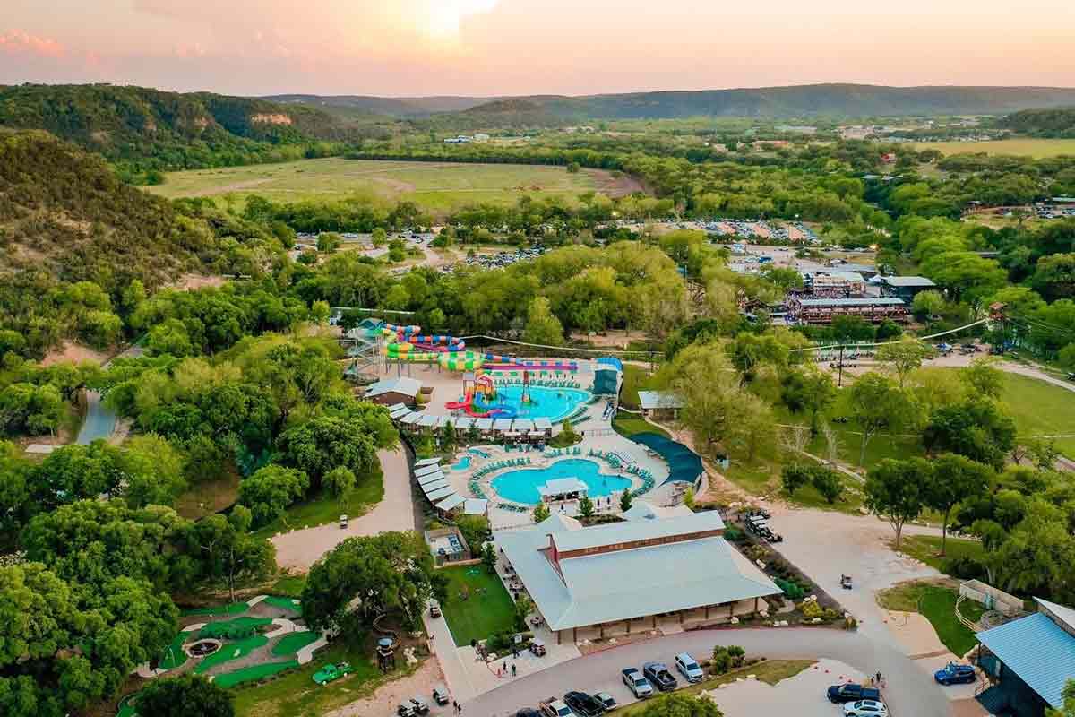 Campground drone shot with mountains, pond, jumping pillow, water park and RV sites at Jellystone Park Luray